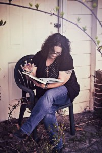 Me sitting in front of a dilapidated house writing.