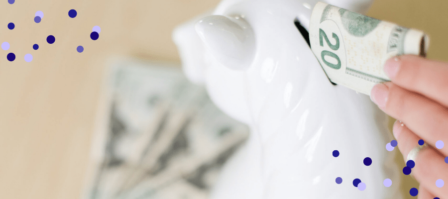 Hand putting money into a unicorn piggy bank