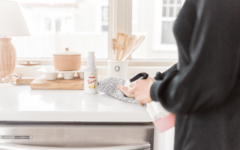 A woman cleaning her home with Thieves Household Cleaner.